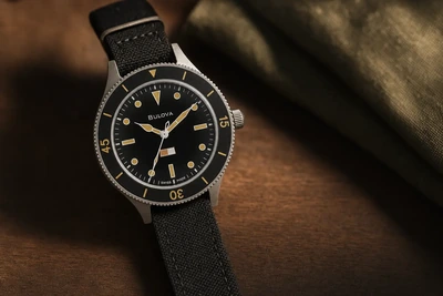 Bulova MIL-SHIPS-W-21 de mostrador preto e pulseira de lona sobre madeira escura