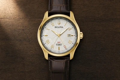 Bulova Wilton automático dourado de correia de couro marrom sobre madeira escura