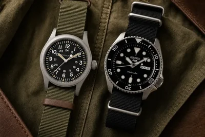 Hamilton Khaki Field e Seiko 5 Sports lado a lado sobre lona oliva