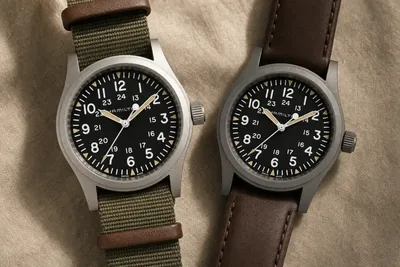 Dois Hamilton Khaki Field lado a lado, um de titânio fosco e outro de aço escovado