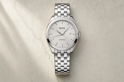 Mido Belluna automático de mostrador prateado e bracelete de aço sobre mesa clara