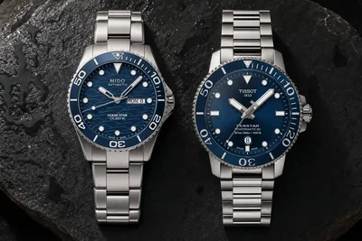 Mido Ocean Star e Tissot Seastar lado a lado sobre pedra escura molhada