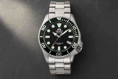 Orient Triton de mostrador verde e bracelete de aço sobre pedra escura