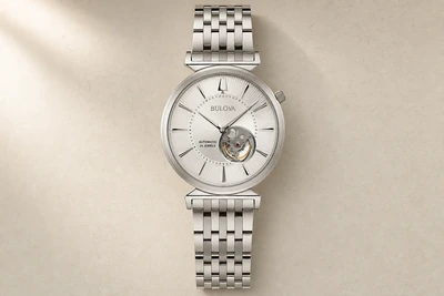 Relógio automático de mostrador prateado e bracelete de aço sobre superfície clara