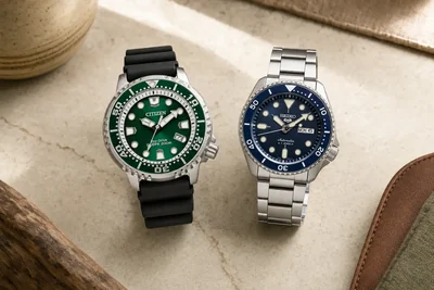 Citizen Promaster verde e Seiko de aço lado a lado sobre pedra clara
