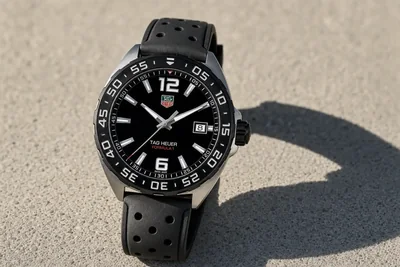 TAG Heuer Formula 1 de mostrador preto e bisel com escala, sobre asfalto claro