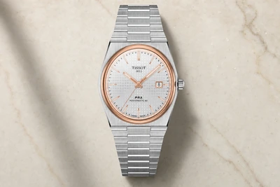 Tissot PRX Powermatic 80 de mostrador branco e bracelete integrado de aço sobre mesa clara