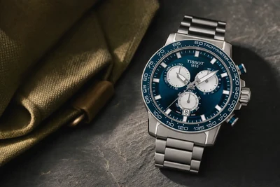 Tissot Supersport cronógrafo de mostrador azul e bracelete de aço sobre pedra escura